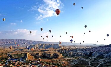 hot air balloons flying over the mountains during daytime