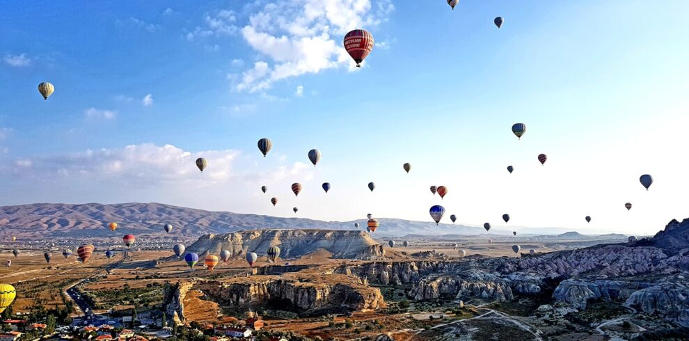hot air balloons flying over the mountains during daytime