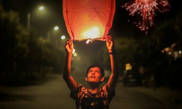niño con una linterna de globo en diwali